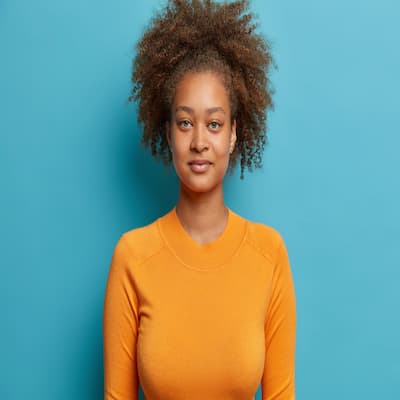 headshot-serious-curly-haired-teenager-girl-looks-satisfied-dressed-casual-orange-jumper(1)