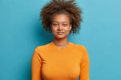 headshot-serious-curly-haired-teenager-girl-looks-satisfied-dressed-casual-orange-jumper(3)(2)